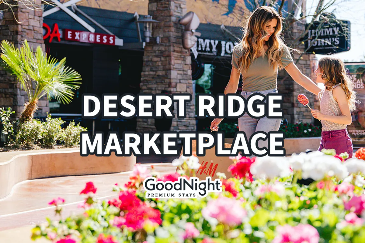 This image captures a lively outdoor shopping and dining area, with people walking among blooming flowers, unique shops, and patios. The scene is vibrant and sociable, evoking a sense of local exploration and community engagement.
